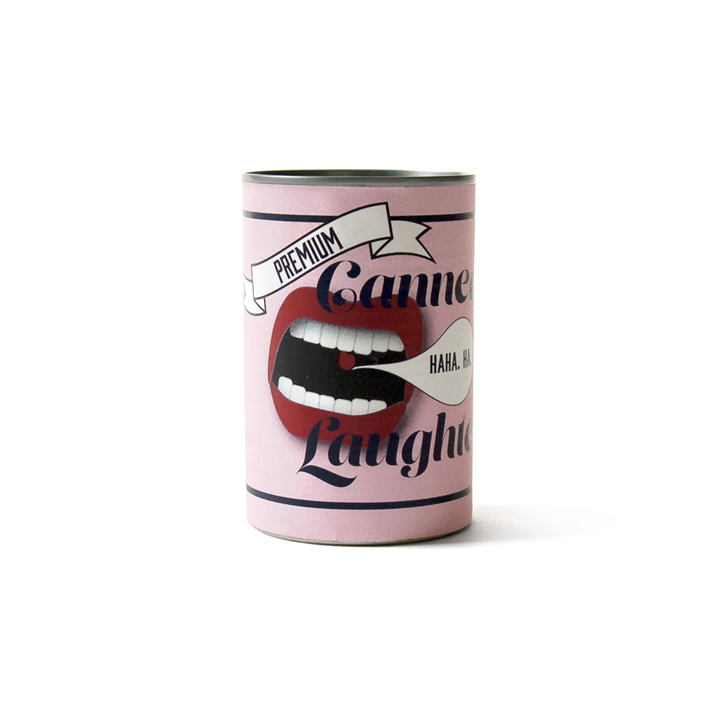 Soup can covered with a pink label. Open mouth with a quote bubble. "Canned Laughter" in sans serif font.
